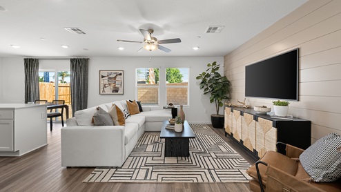 Photo of open concept living room with a couch, coffee table, and entertainment center