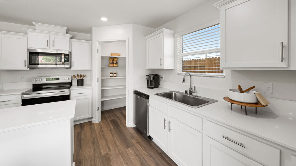 kitchen with white cabinets, white countertops and stainless steel appliances