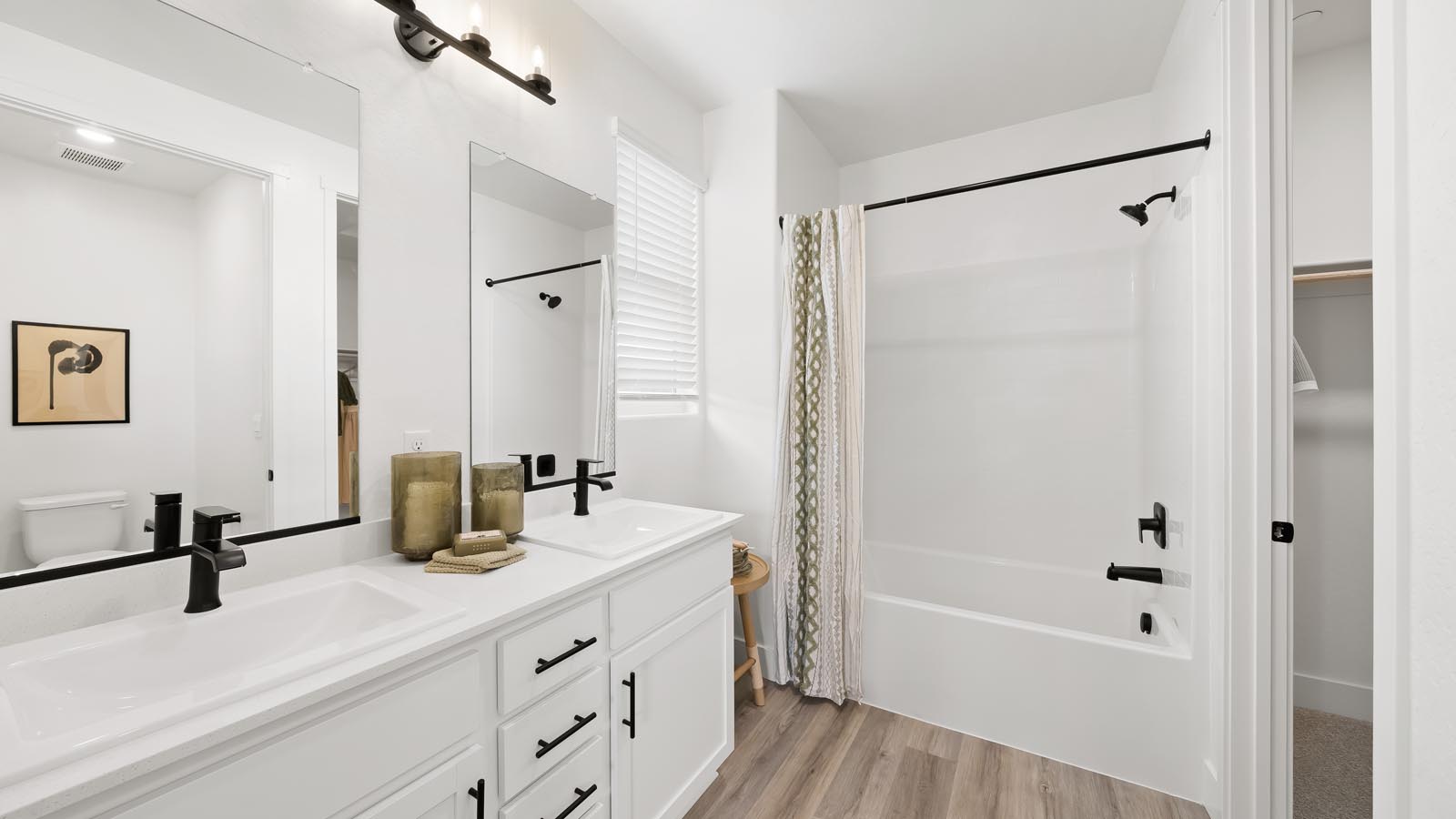 primary ensuite bathroom with white countertops and cabinets