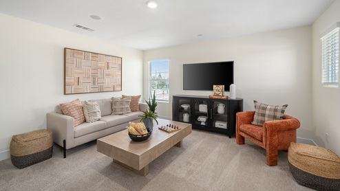 Photo of upstairs loft with a couch, chair, coffee table and entertainment center