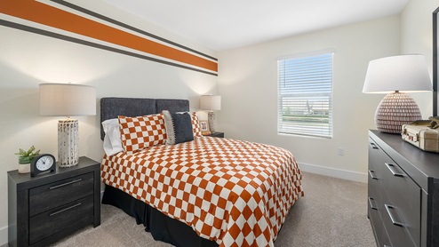 Photo of kids bedroom with orange decor and a large window