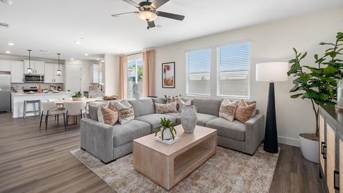 Photo of open concept living room with large sectional couch, coffee table, and rug