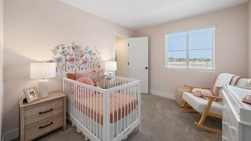 Photo of nursery with pink decor and a white crib
