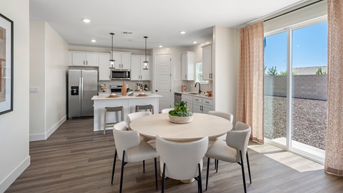 Photo of open concept dining room and kitchen with sliding glass door leading ot backyard