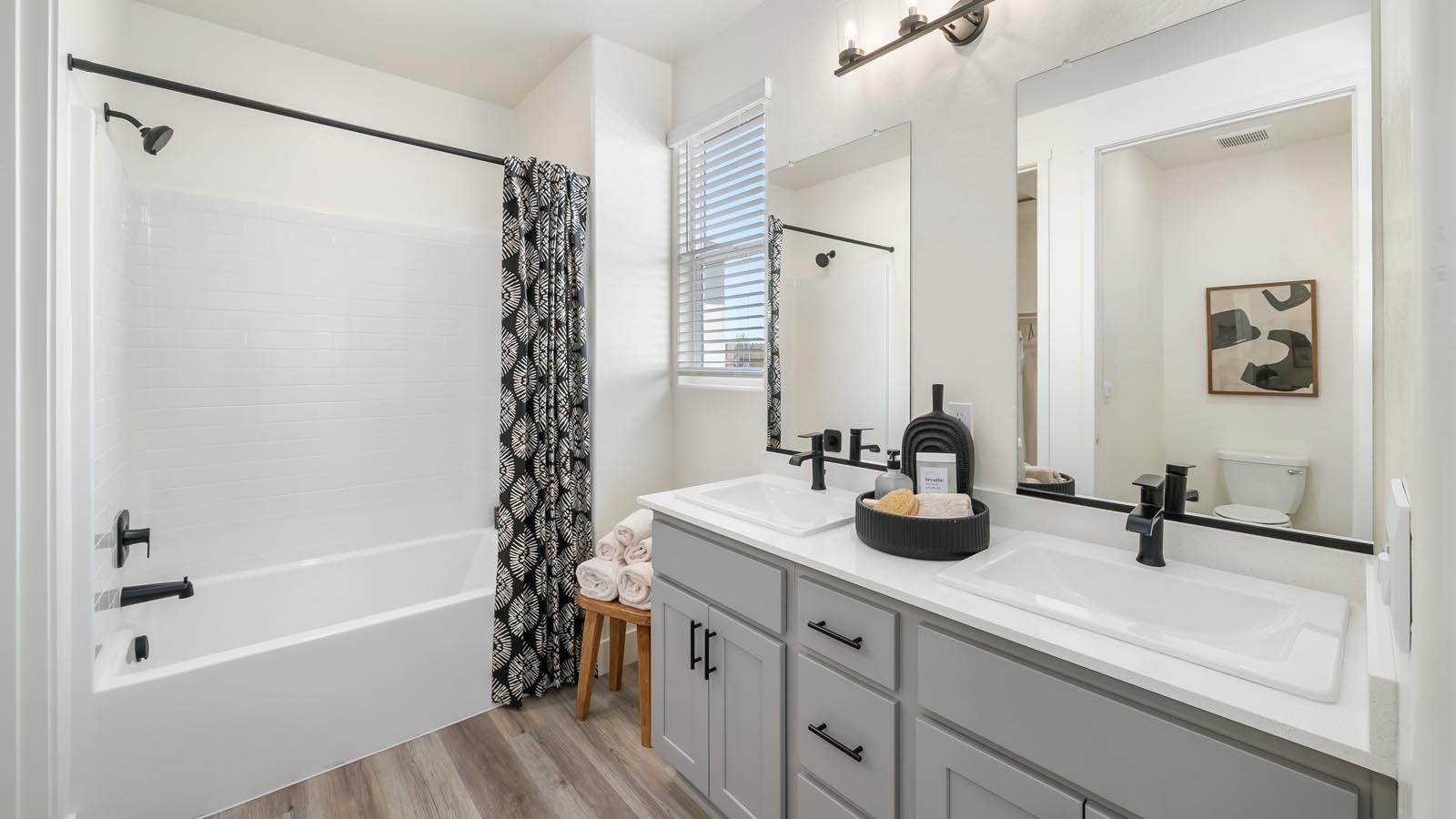 primary bathroom with white countertops and gray cabinets