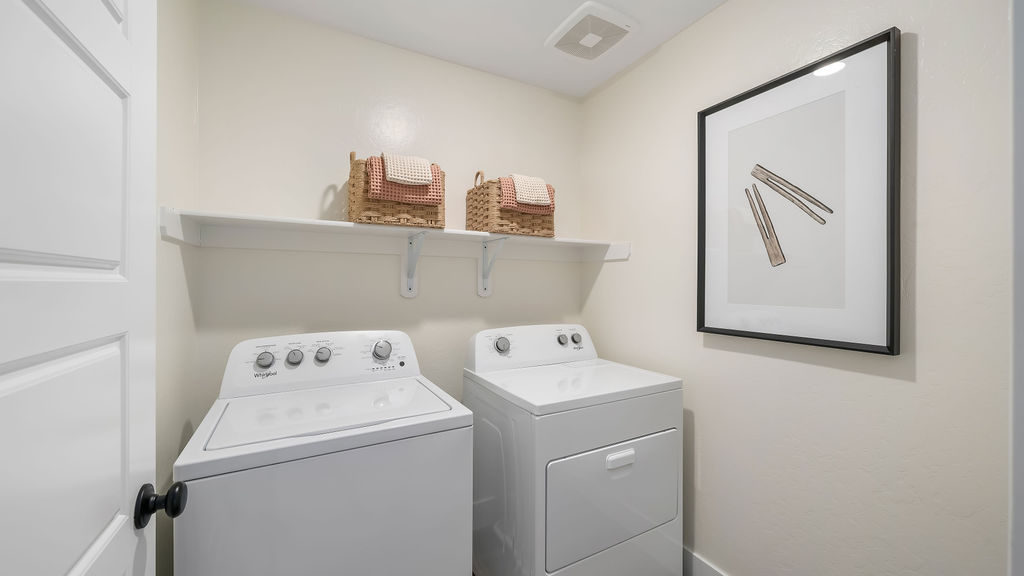 Laundry room with washer, dryer, and storage shelf