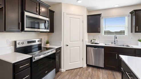 Open concept kitchen with large island and white countertops with brown cabinets