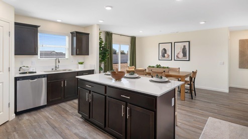 Open concept kitchen with large island and white countertops with brown cabinets