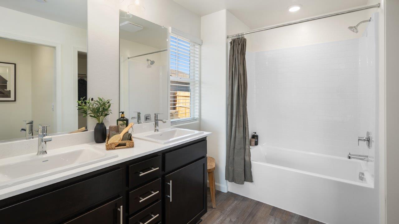 primary bathroom with white countertops and brown cabinets