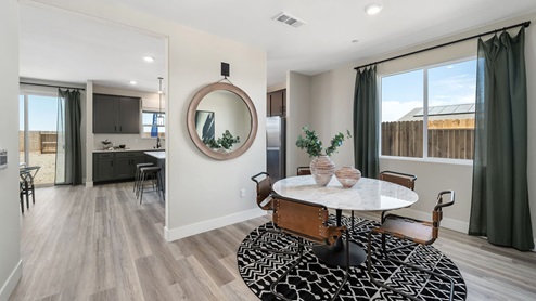 Photo of open concept informal dining room with small table and large window