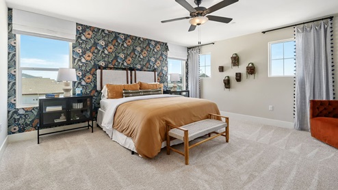 Photo of primary bedroom with king size bed and large windows