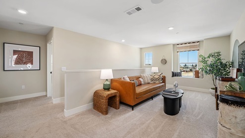 Photo of upstairs loft with couch, coffee table, and chairs