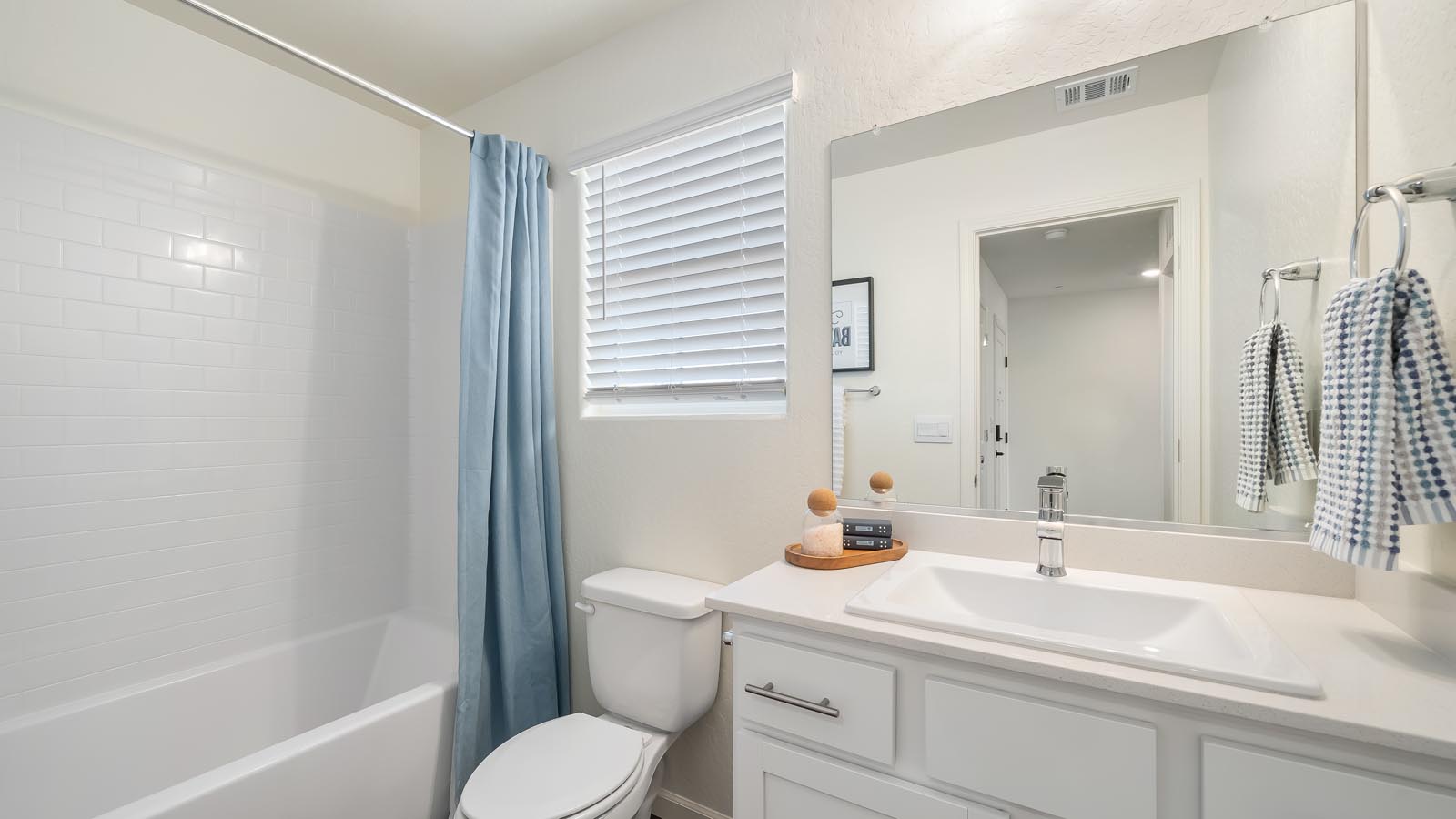 Interior photo of guest bathroom with white cabinets and countertops