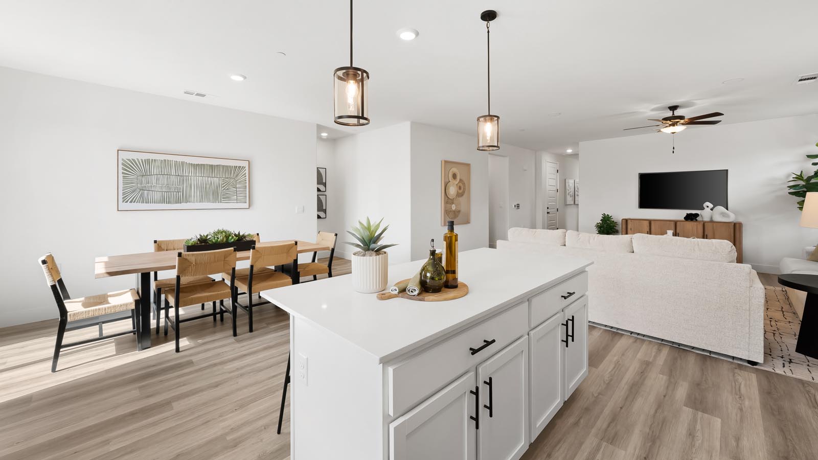 Interior photo of open concept kitchen with an island, white cabinets, white countertops, and stainless steel appliances