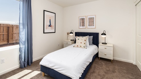 Kid's bedroom with a large window and art on the walls