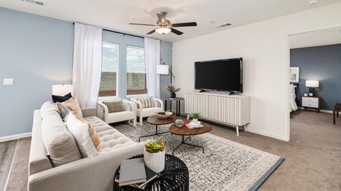 Image of open-concept living room with large windows, a couch, chairs and coffee table