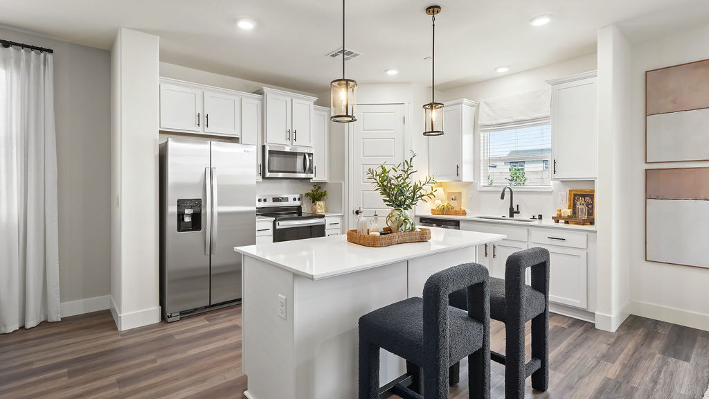 Kitchen with two black bar chairs.