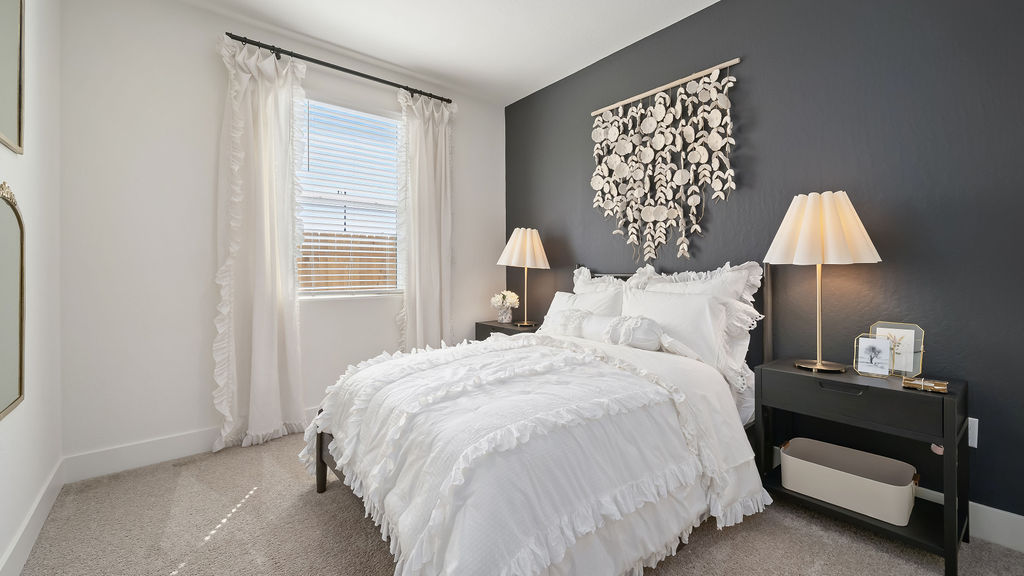 Kids room with blue accent wall and white bedding.