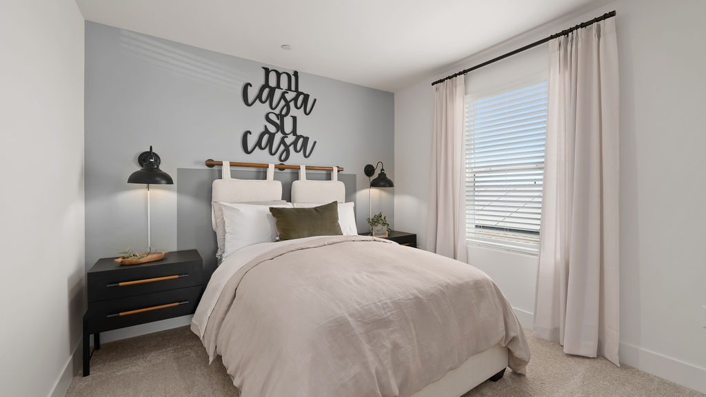 Bedroom with grey bedding and accent wall.