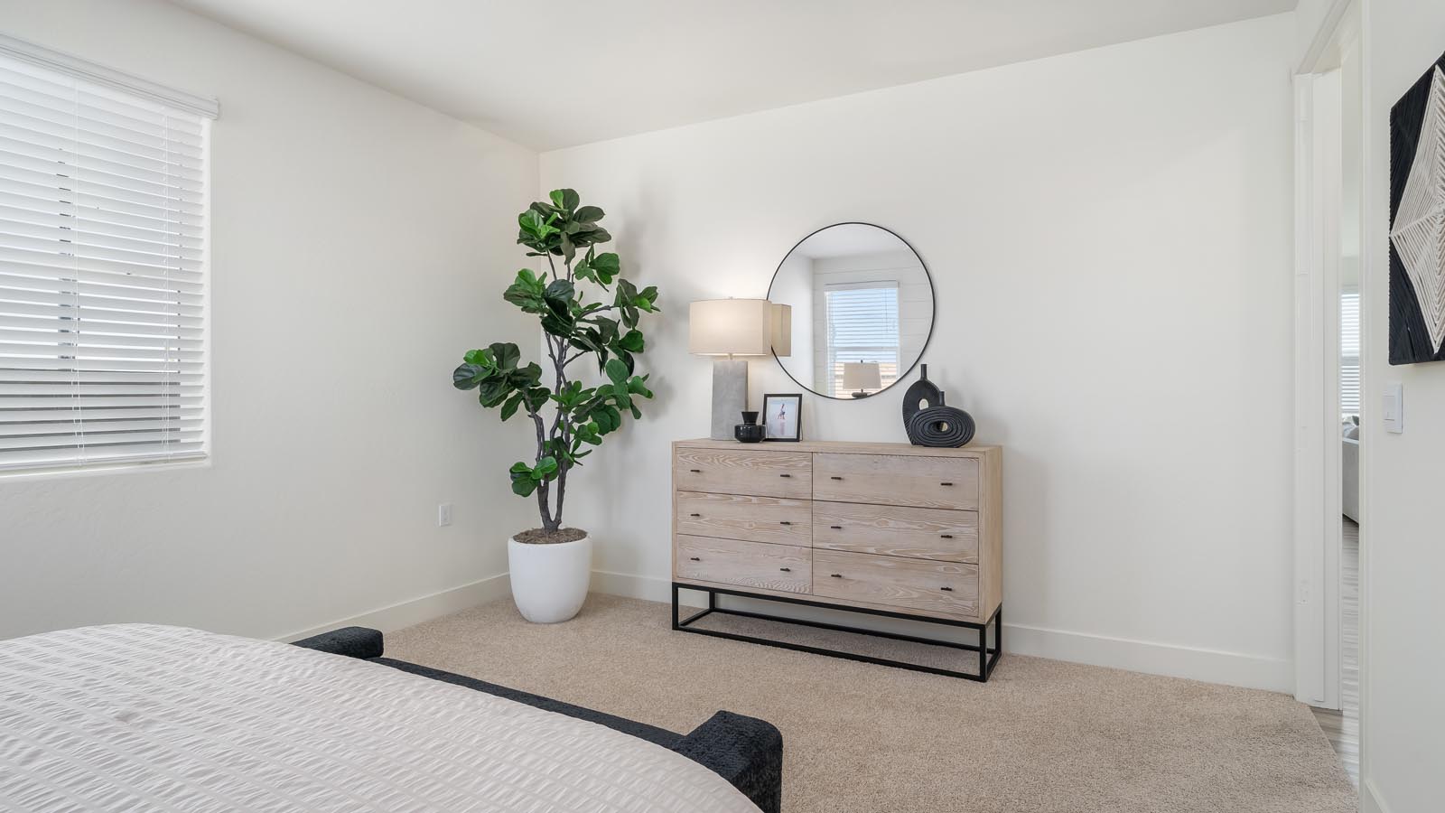 Interior photo of primary bedroom with king size bed, matching end tables and large windows