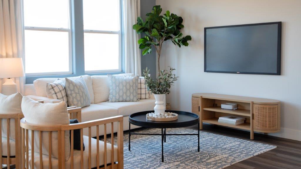 living room with white couch and chairs.