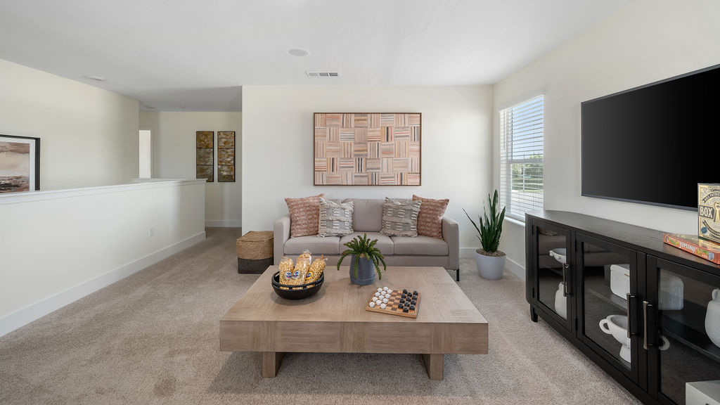 upstairs loft with a coutch and entertainment center.