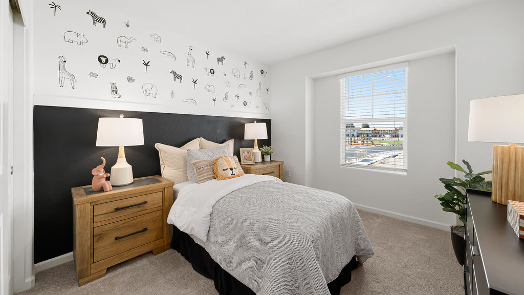 Bedroom with grey bed and animals on the wall.