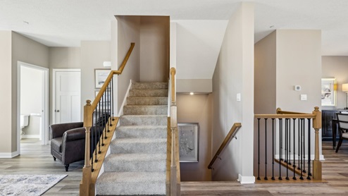 Exposed wood handrails going to upper level and main level