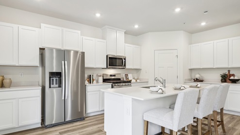 Kitchen with white cabinets and counter tops with stainless steel applainces