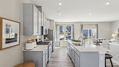 Kitchen with light gray cabinets and white quartz countertops