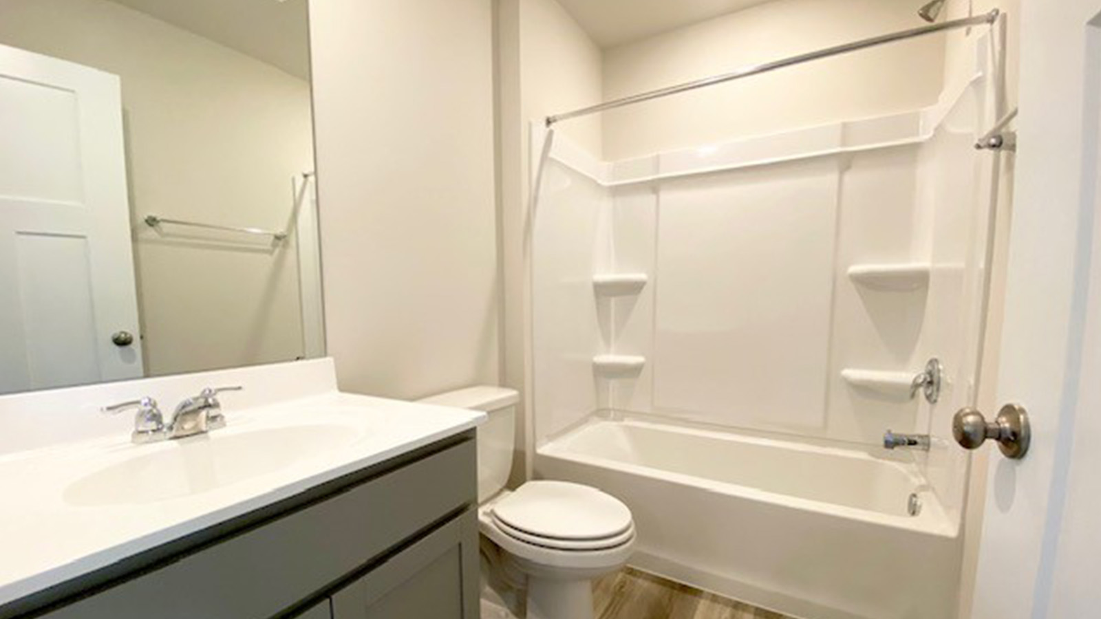 secondary full bathroom with grey cabinets