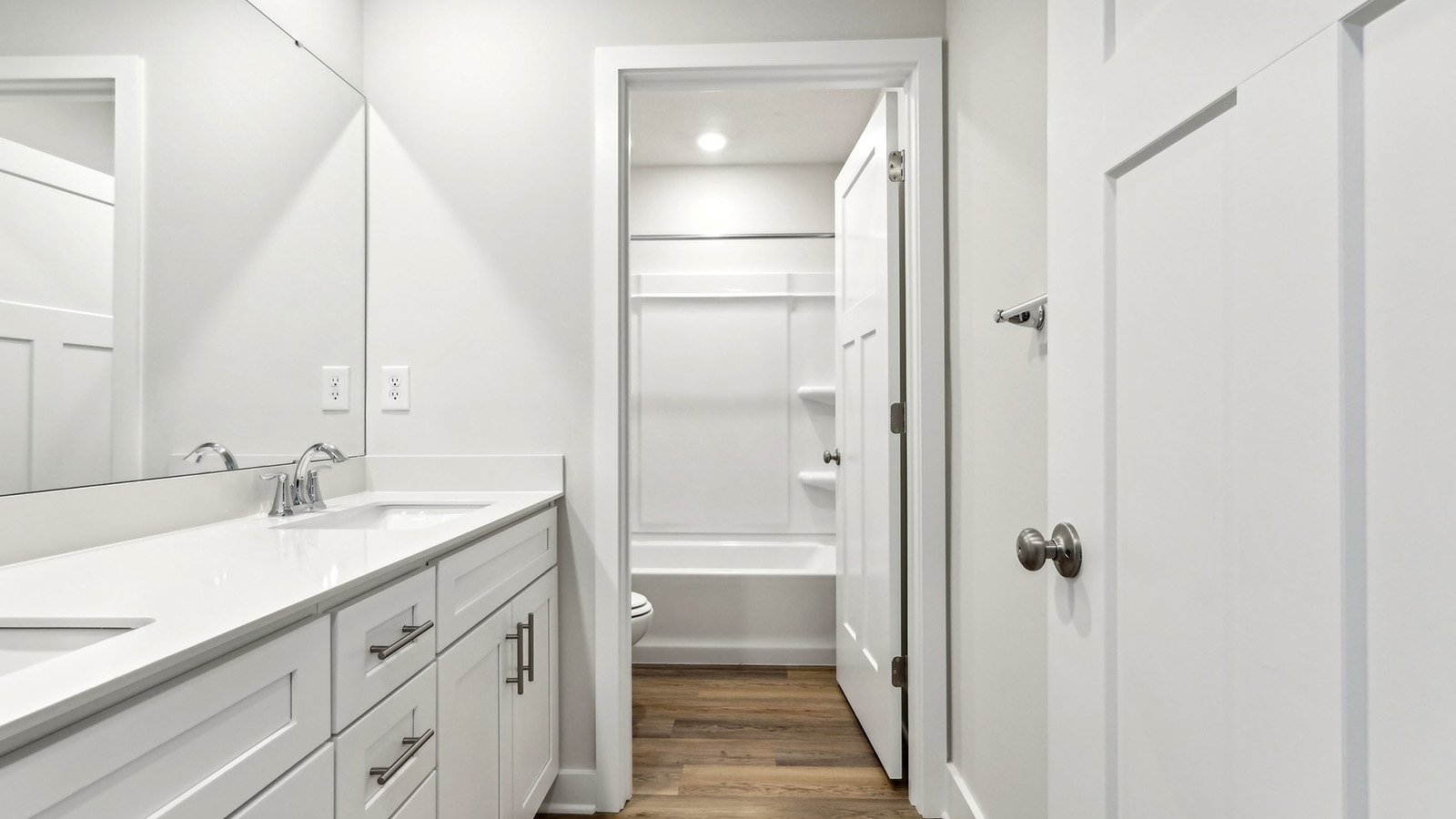 primary en suite bathroom with dual vanity and glass shower door
