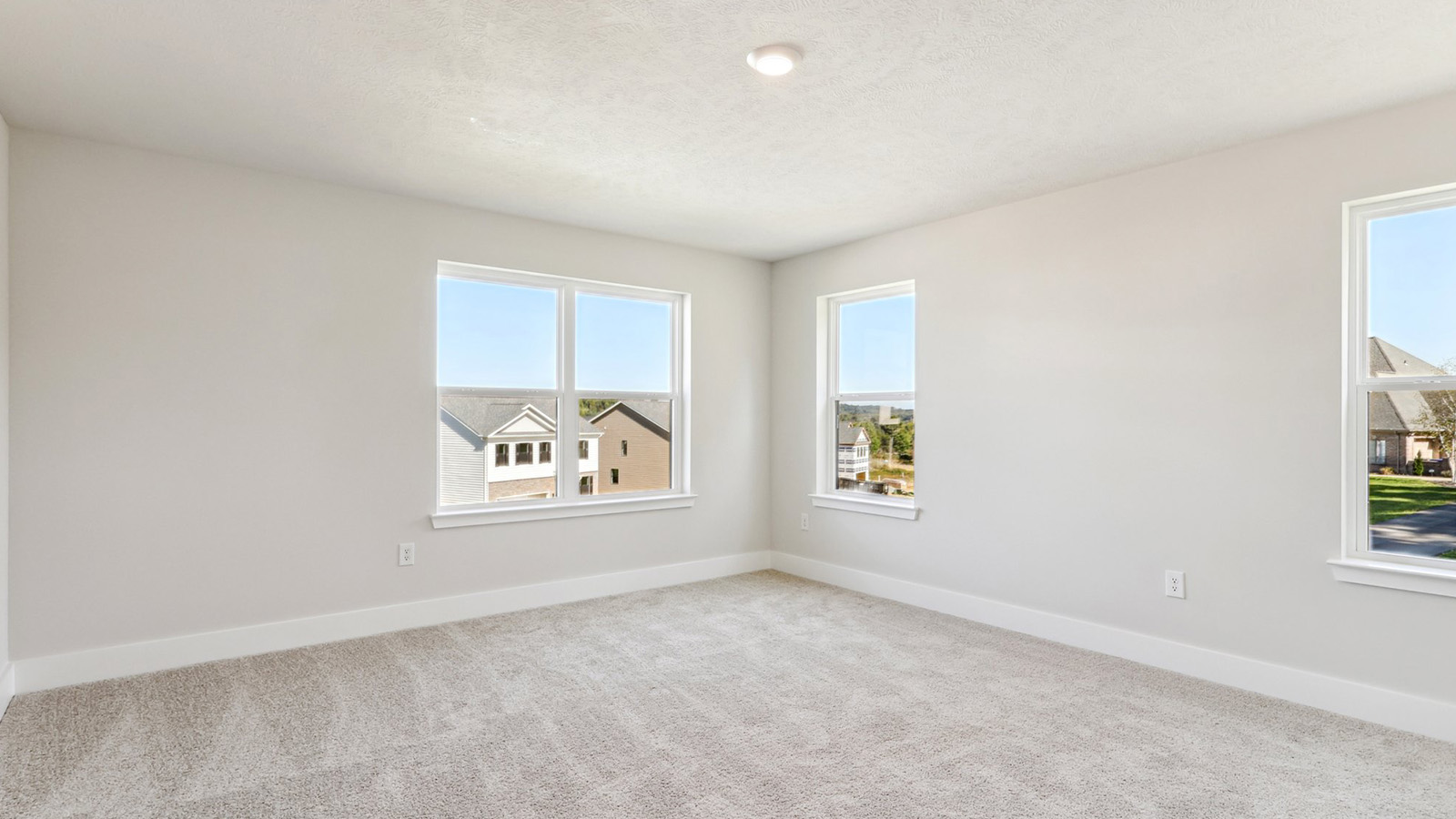 Second floor primary master en suite bathroom with light tan carpet and three large windows