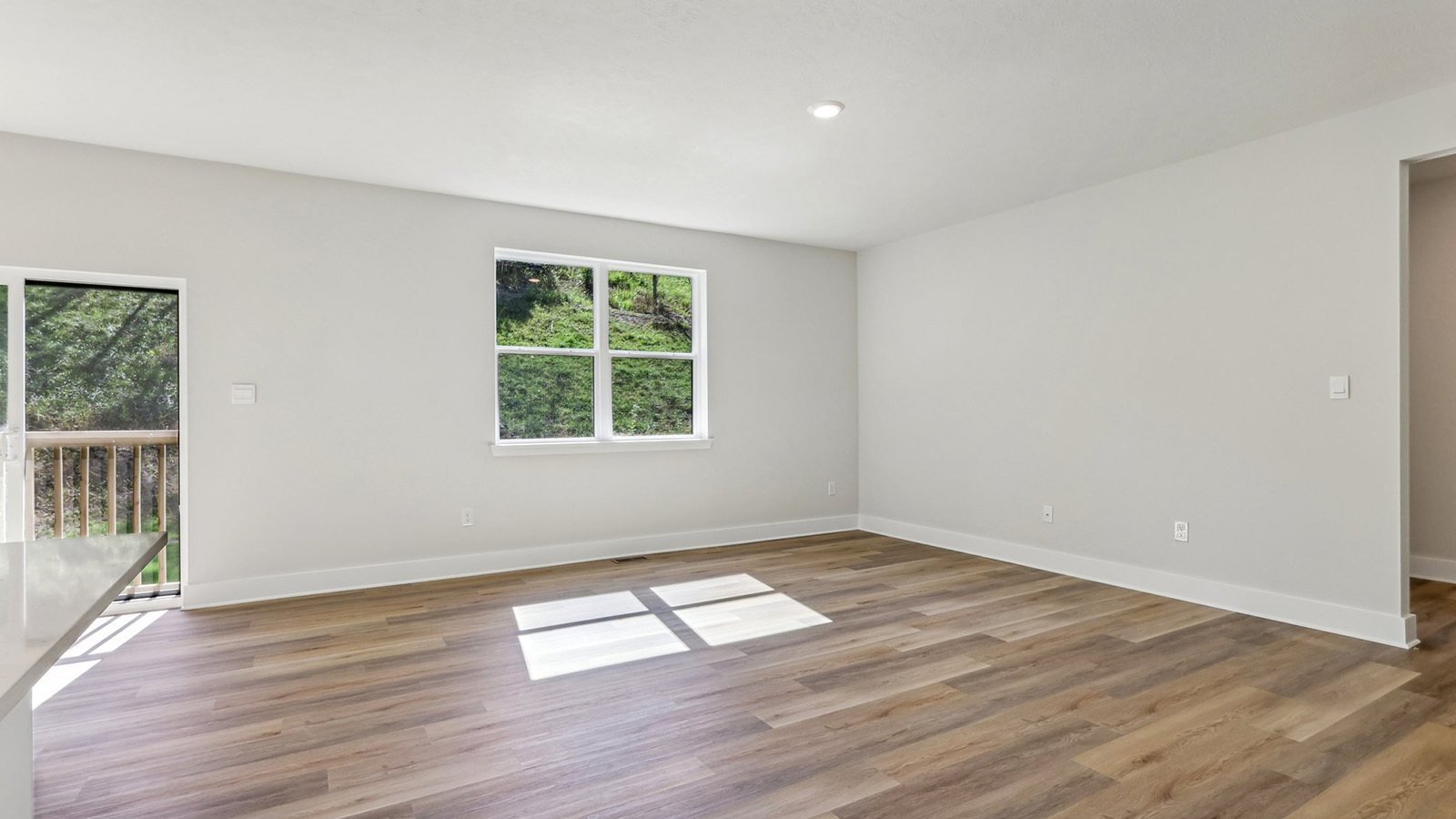 Main level living space with brown LVP floors and large windows
