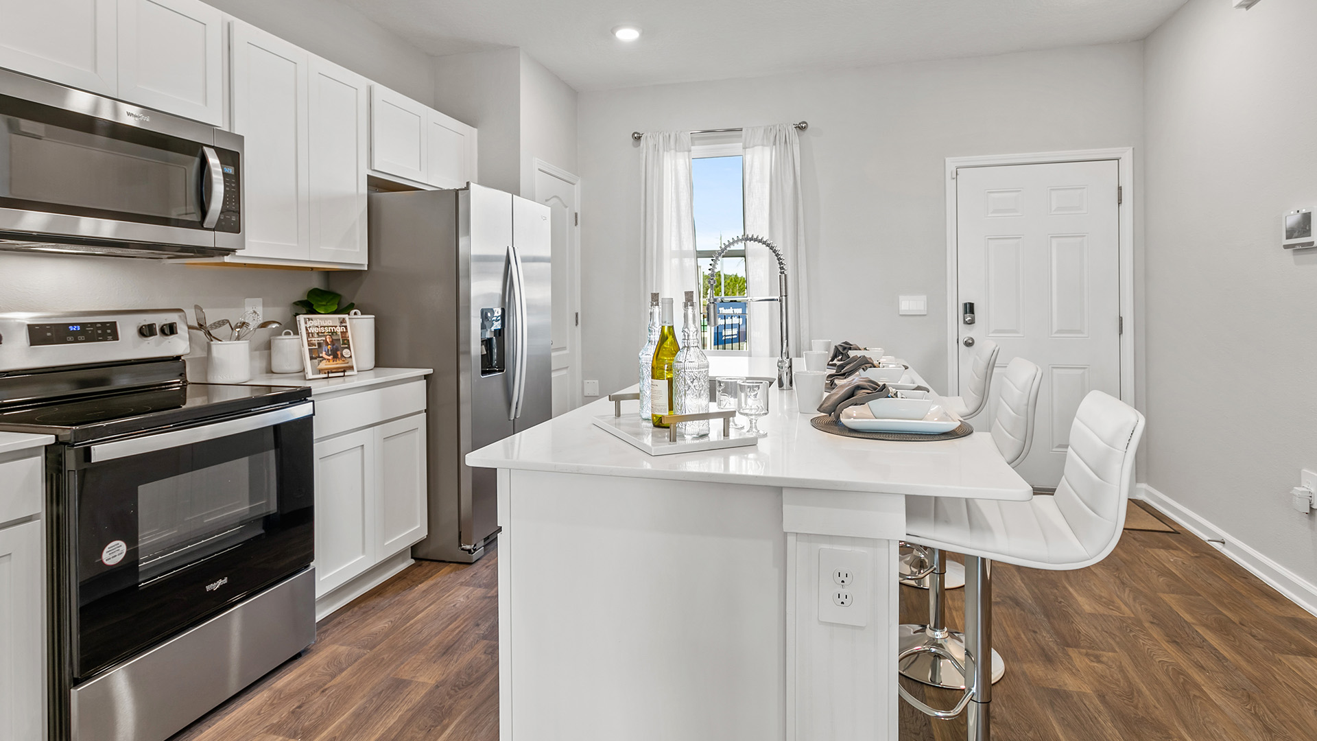 Interior kitchen with white cabinets and island and window