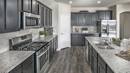 kitchen with elongated countertops, brown cabinets and stainless steel appliances