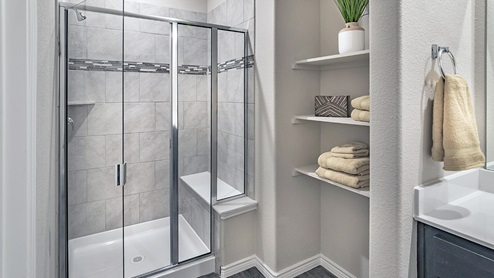 primary bathroom shower with bench and storage shelves