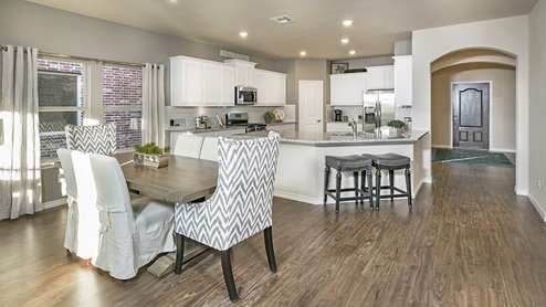 large kitchen with white cabinets next to front door entry
