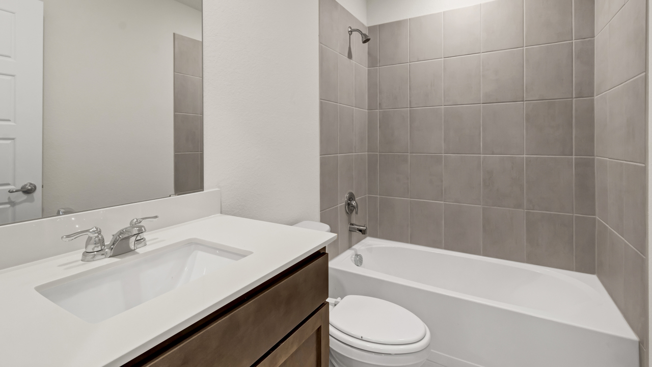 secondary bathroom with vanity, commode and garden tub