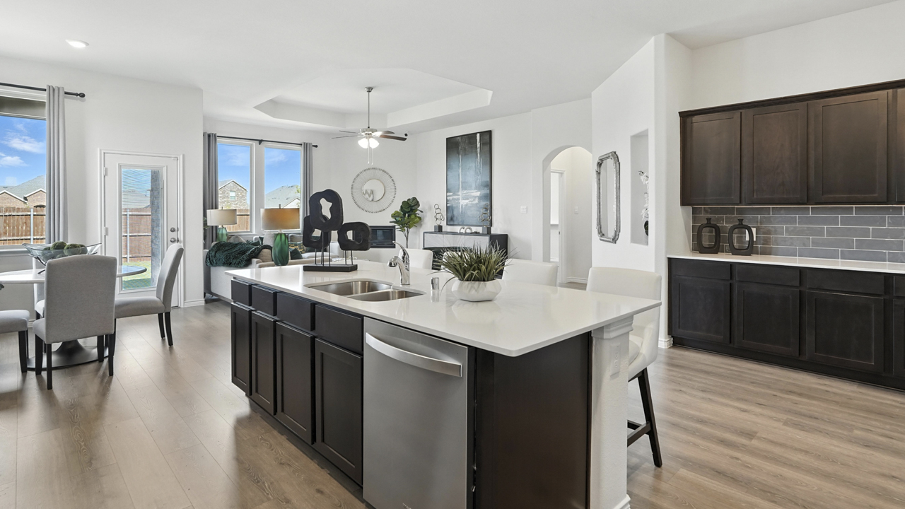 kitchen area with hardwood floors light counters and dark cabinets