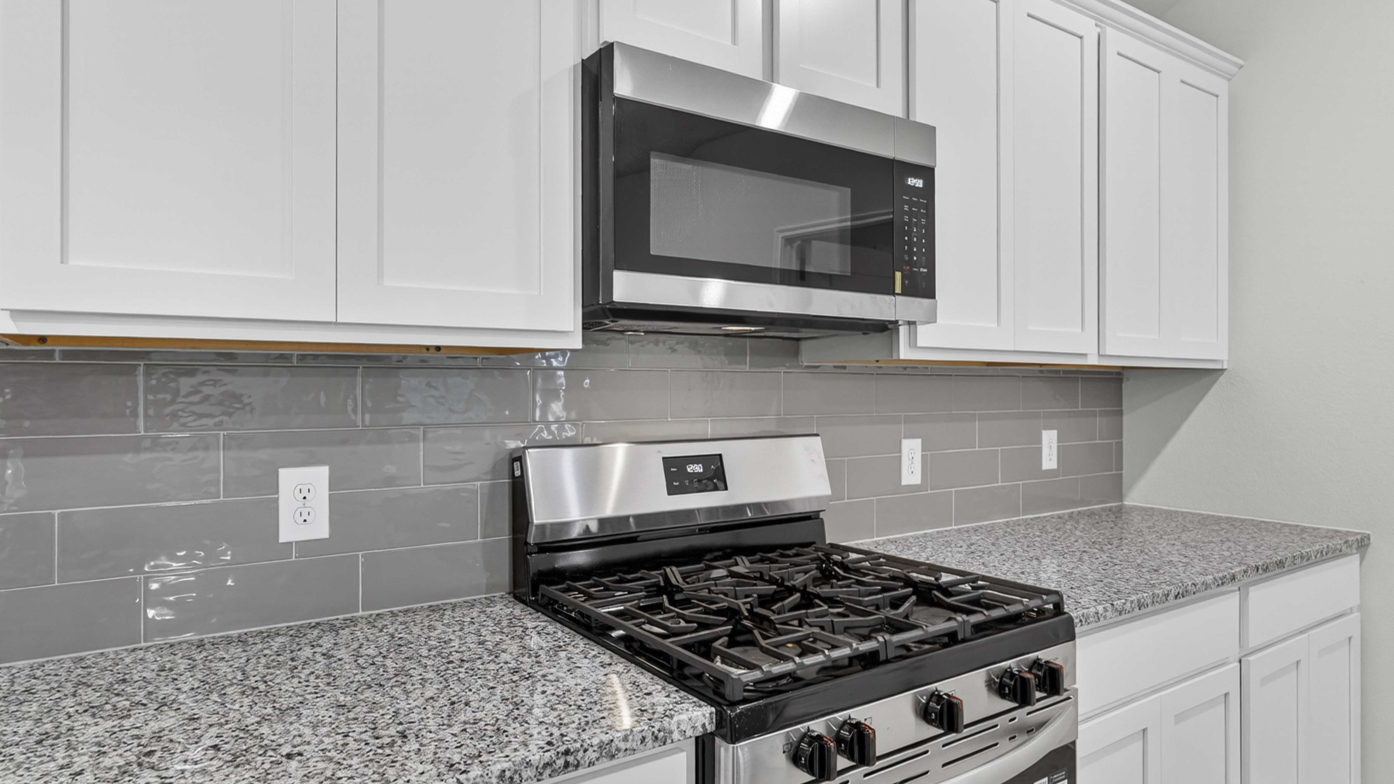 kitchen area with white cabinets and granite counters