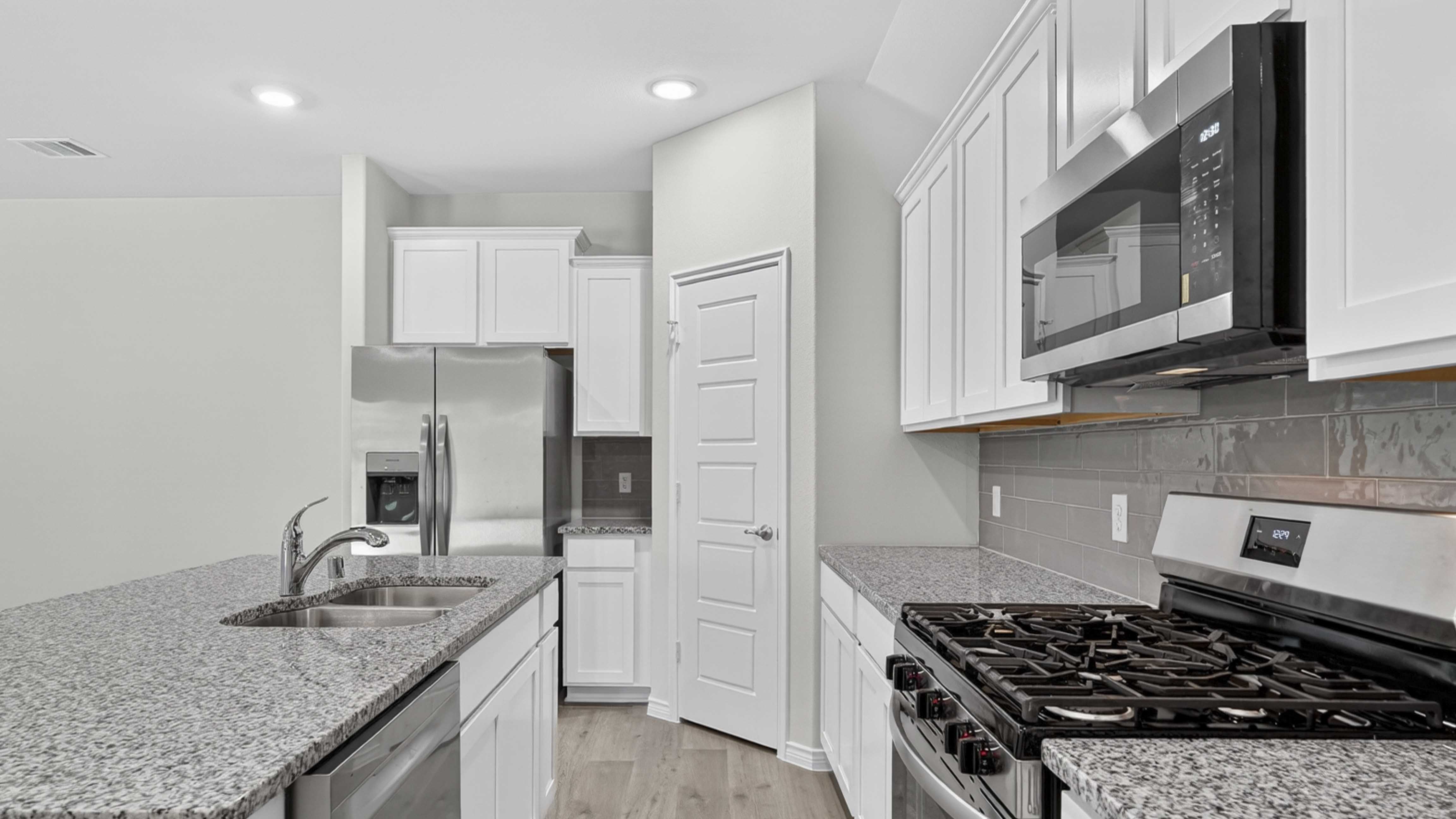 kitchen area with white cabinets and granite counters