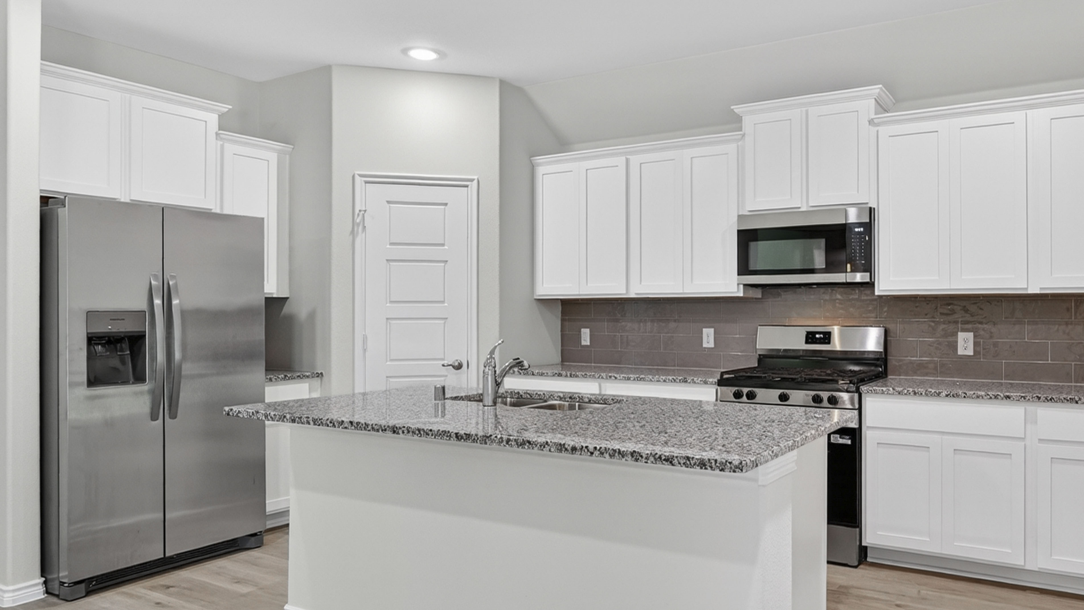 kitchen area with white cabinets and granite counters