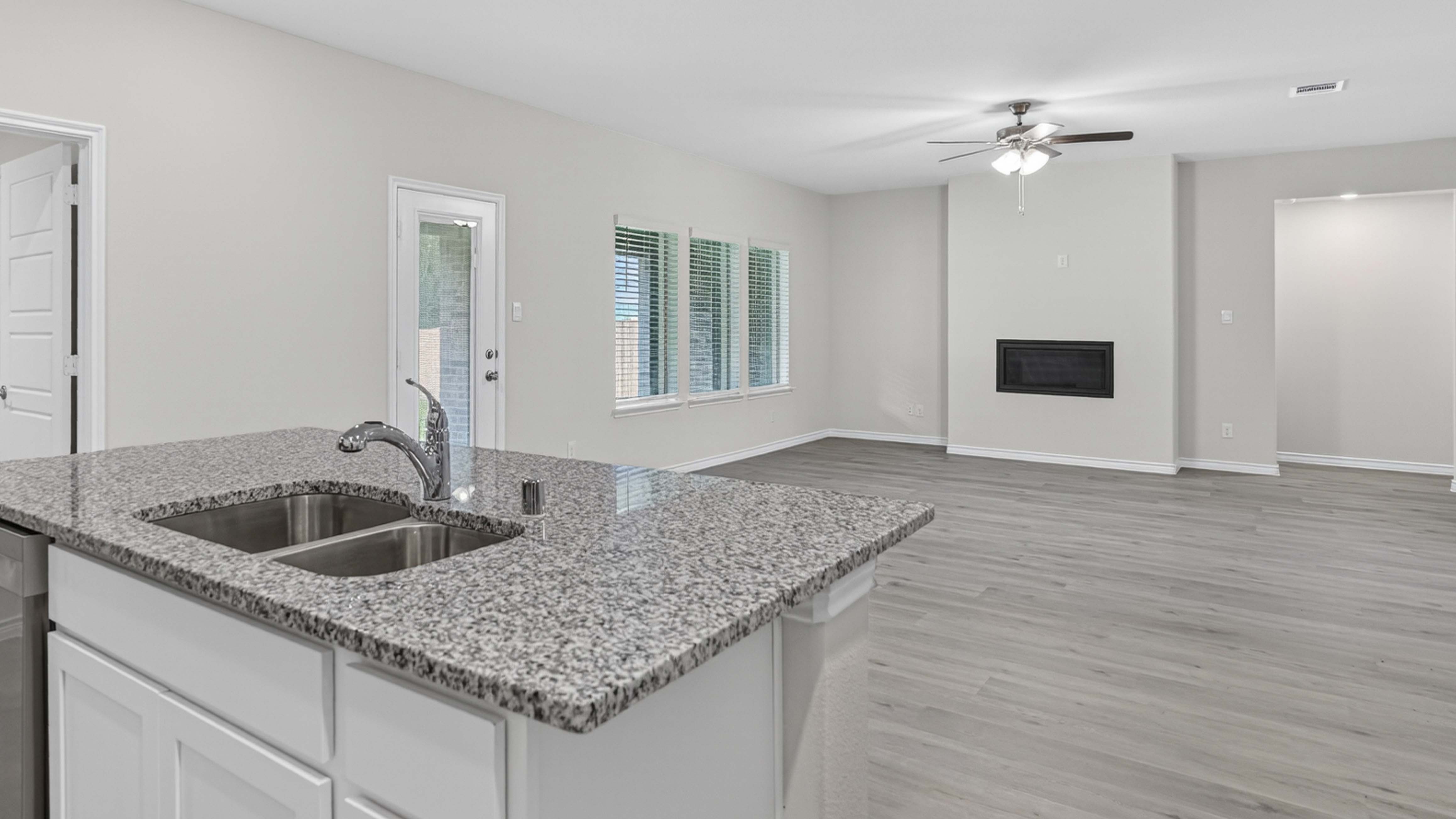 open concept living area with hard wood floors and large windows facing the backyard