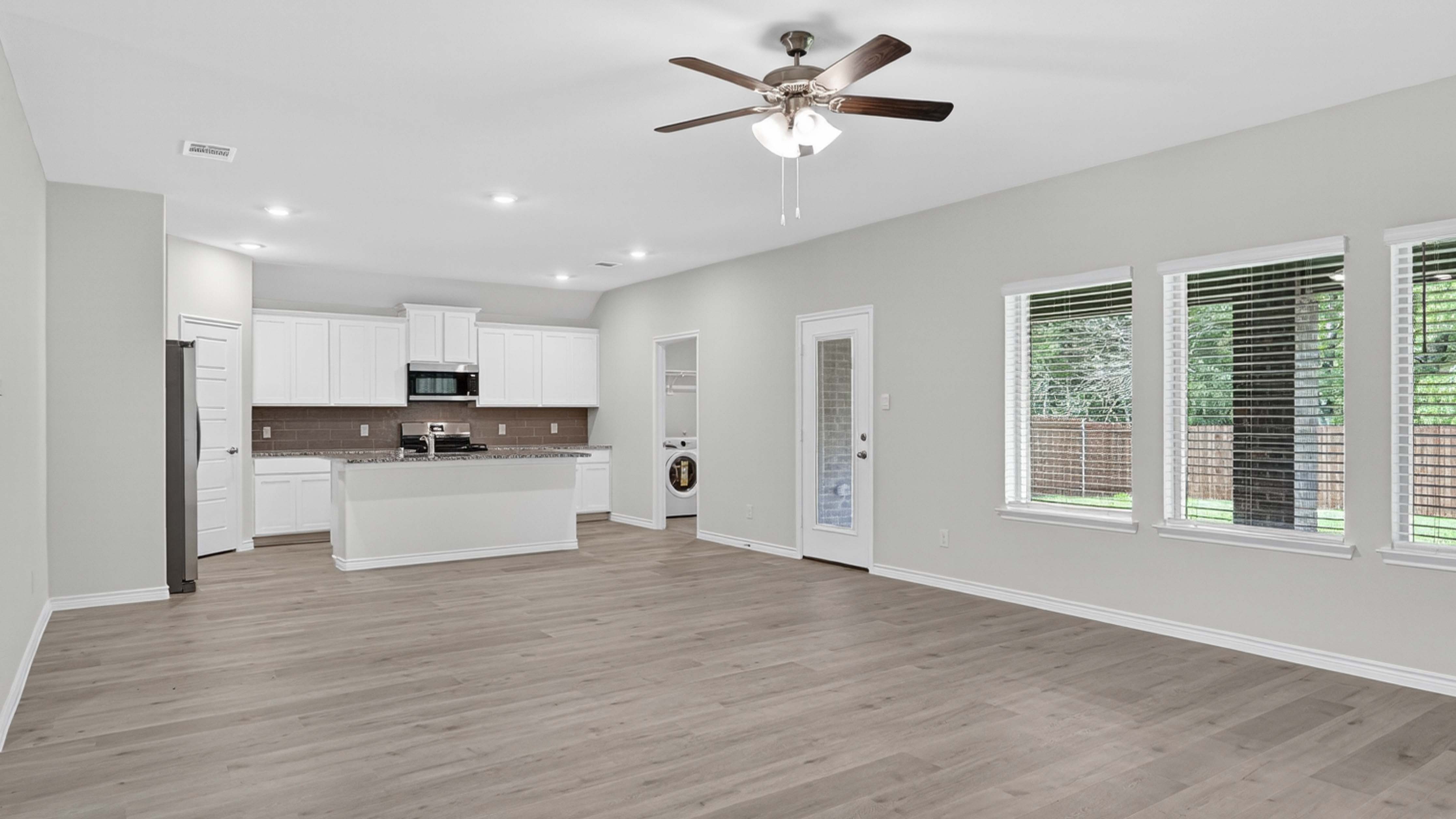 open concept living area with hard wood floors and large windows facing the backyard