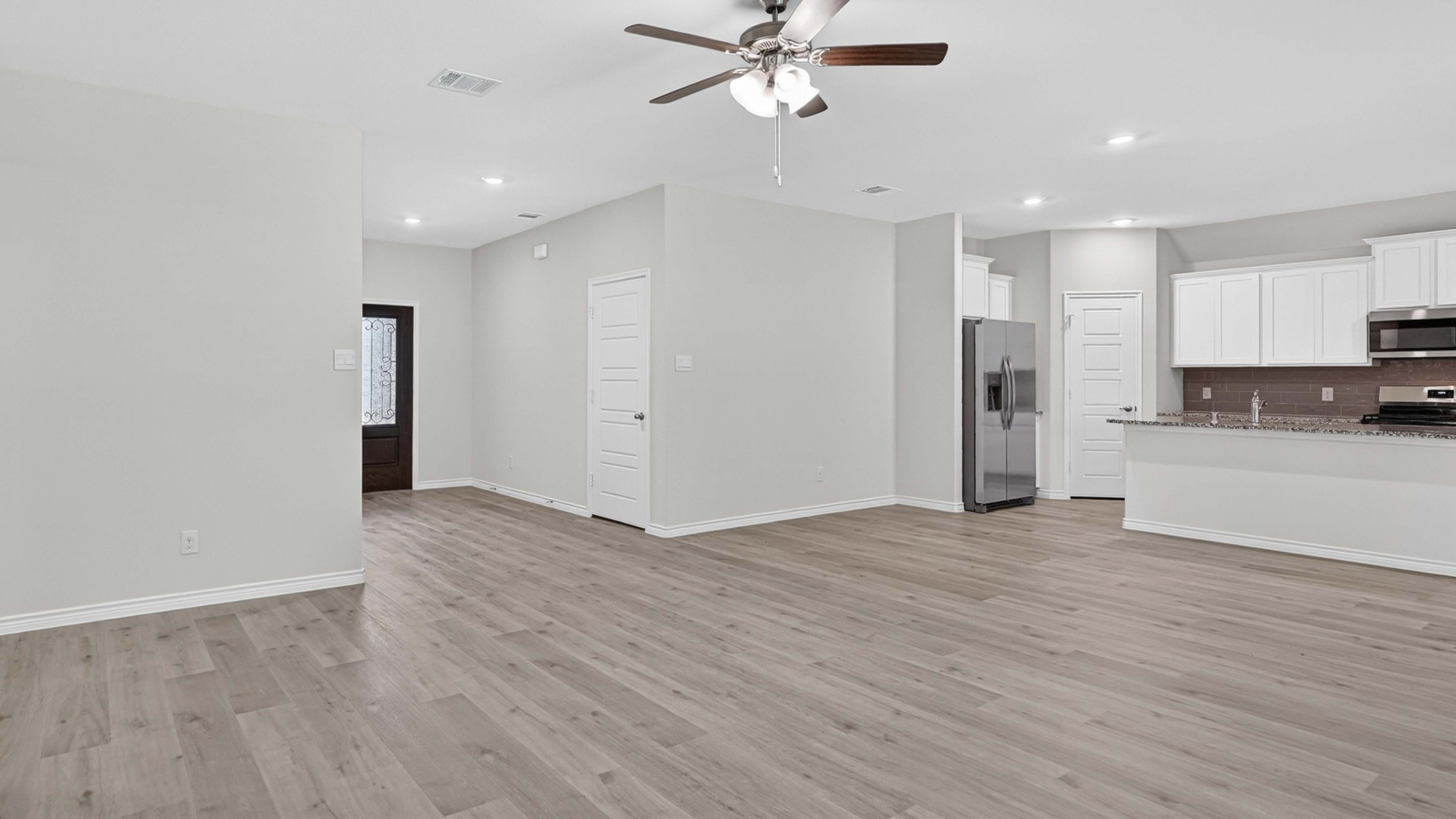 open concept living area with hard wood floors and large windows facing the backyard