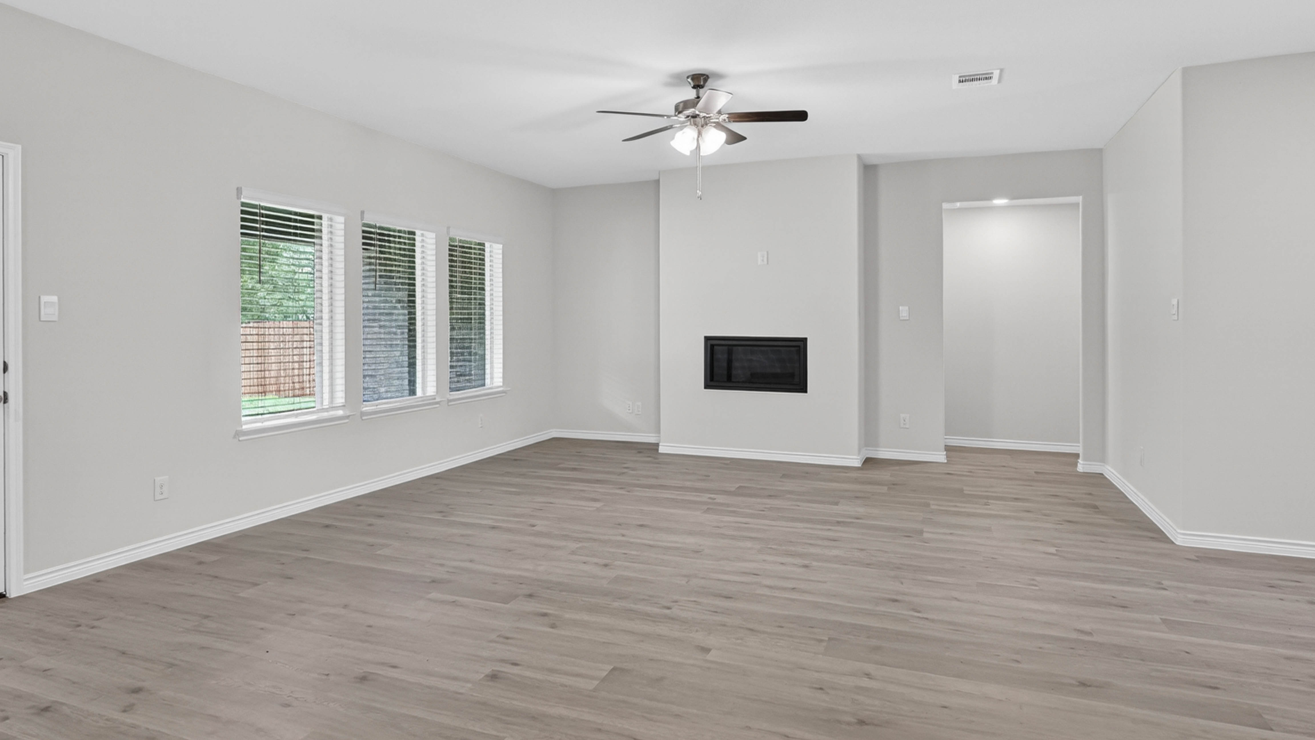 open concept living area with hard wood floors and large windows facing the backyard