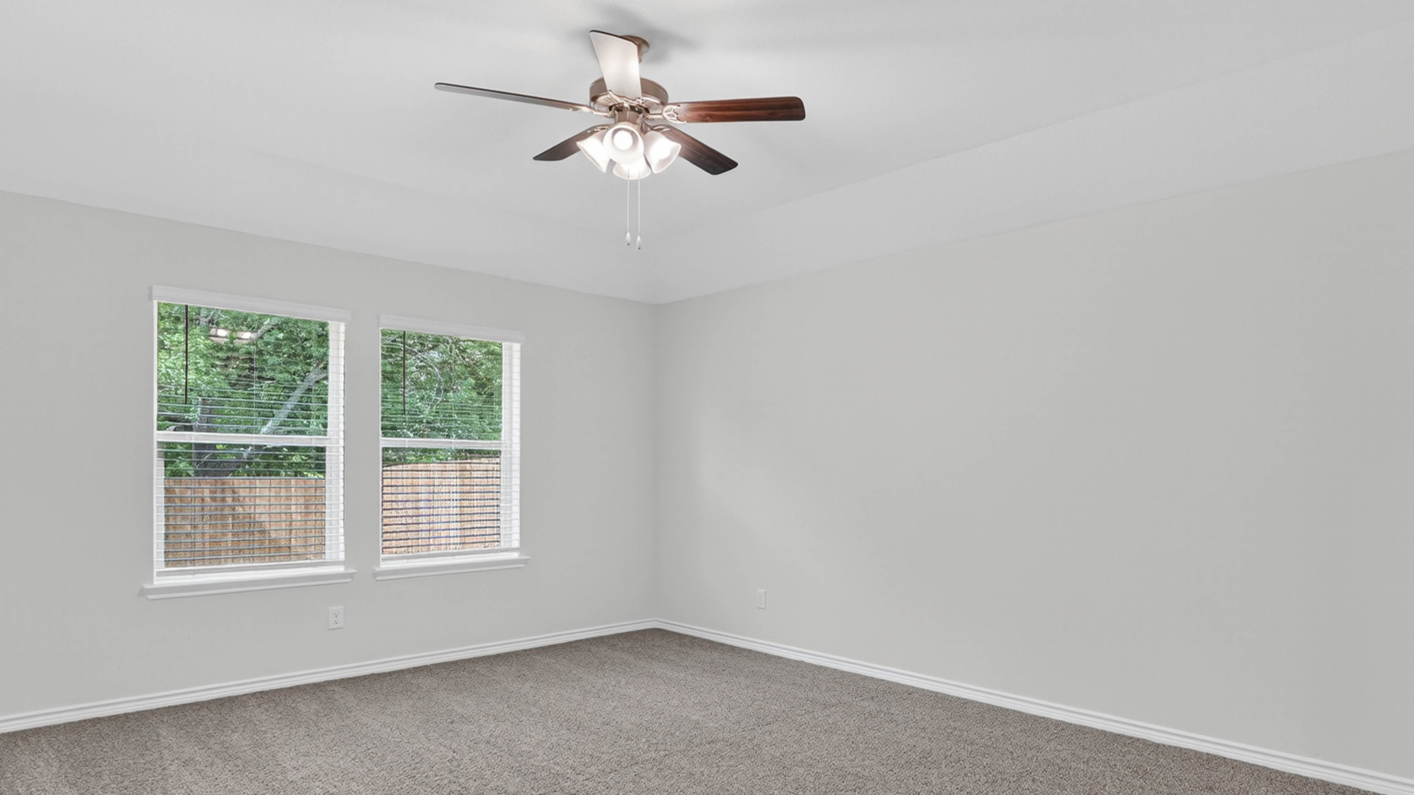primary bedroom with large windows facing the backyard