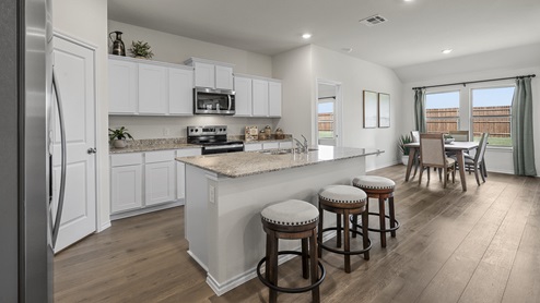 1304 Quest Bridge Road Model kitchen area with granite counters and white cabinets with view of open concept living area