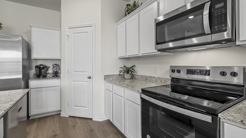 1304 Quest Bridge Road Model kitchen area with granite counters and electric appliances